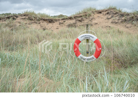 A lifebuoy sign in the dunes of laholm standing in the gras of melbystrand Sweden 106740010