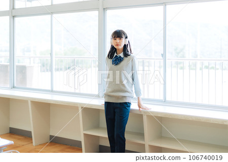 穿著褲子風格的高中女孩在教室裡聽音樂 穿著褲子風格的高中女孩在教室裡聽音樂 106740019