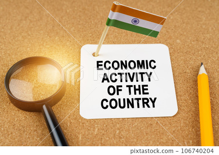 Economy and finance concept. On the table are a magnifying glass, a pencil, the flag of India and a sheet of paper with the inscription - economic activity of the country 106740204