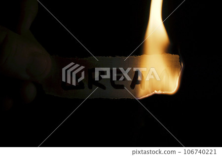 A man holds a paper with the inscription - Dream in his hands, which he then burns. 106740221