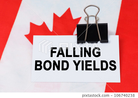 Economy and finance concept. On the flag of Canada lies a business card with the inscription - falling bond yields Economy and finance concept. On the flag of Canada lies a business card with the inscription - falling bond yields 106740238