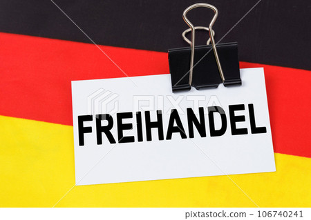 Economy and finance concept. On the flag of Germany lies a business card with the inscription - free trade. Text in German. 106740241