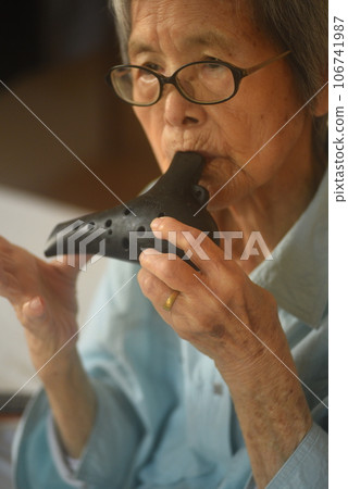 Elderly man playing the ocarina Elderly man playing the ocarina 106741987