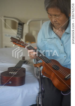 Elderly woman enjoying musical instruments 106742258