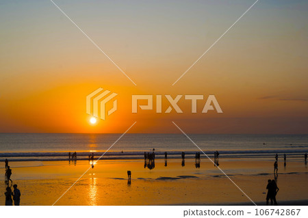 The silhouette of people engaged in activities, enjoying the sunset on Kuta Beach in Bali. The silhouette of people engaged in activities, enjoying the sunset on Kuta Beach in Bali. 106742867