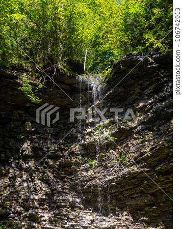 A small waterfall with crystal cold water in the Carpathians 106742913