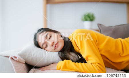 Asian woman resting at home on couch 106743333
