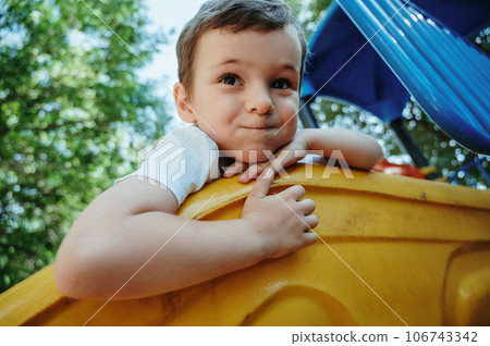 happy child kindergarten boy playing on slide on playground in summer 106743342