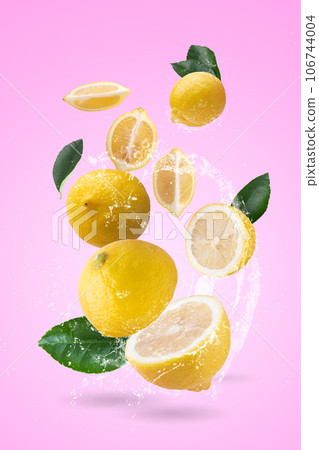 water splash on yellow lemon isolated on a pink background. 106744004
