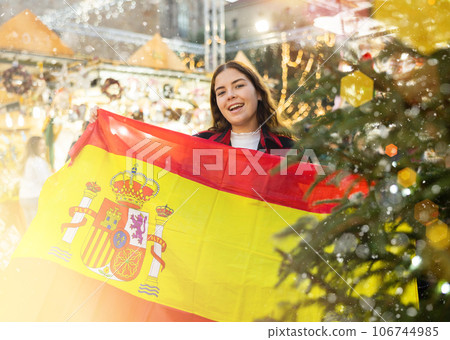 Woman waving Spanish flag at street new year fair 106744985