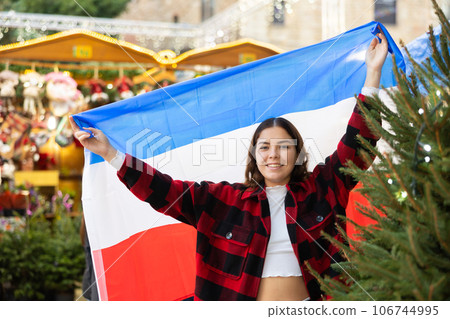Cheerful girl with flag of Netherlands at Christmas city market 106744995