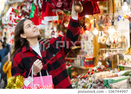 Happy young girl walking through street Christmas fair 106744997