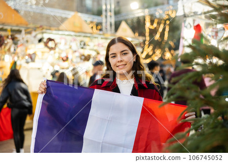 Cheerful girl with flag of France at Christmas city market Cheerful girl with flag of France at Christmas city market 106745052