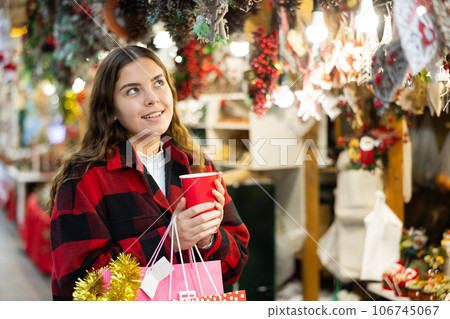 Happy girl with paper cup of coffee walking in Christmas fair Happy girl with paper cup of coffee walking in Christmas fair 106745067