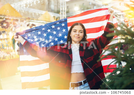 Woman waving USA flag at street new year fair 106745068