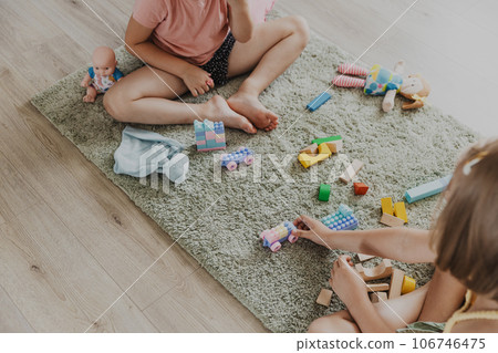 Children playing with colorful plastic toy colourful train. Kids sitting on carpet indoors at sunny white home bedroom or kindergarten, nursery. Funny educational eco-friendly game for child Children playing with colorful plastic toy colourful train. Kids sitting on carpet indoors at sunny white home bedroom or kindergarten, nursery. Funny educational eco-friendly game for child 106746475