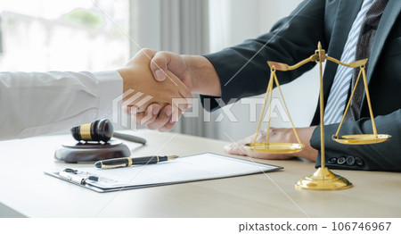Handshake after Lawyer providing legal consult business dispute service to the man at the office with justice scale and gavel hammer Handshake after Lawyer providing legal consult business dispute service to the man at the office with justice scale and gavel hammer 106746967