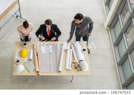 Engineer team meeting to inspect the construction blueprint drawings, work plan and distribute work before starting the building 106747035