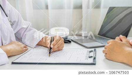 Doctor hand holding pen and explained examination results to the patient man, healthcare and medical checkup concept 106747503