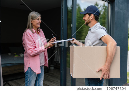 Courier man delivering parcel to woman client. Courier man delivering parcel to woman client. 106747804