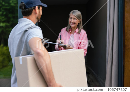 Woman hand accepting delivery of boxes from deliveryman. 106747807