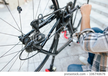 Close up of mans hands reparing bike transmission system 106748676
