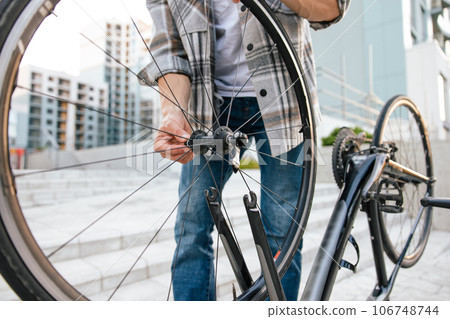Man with a bike on the steps in the street 106748744
