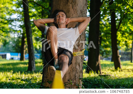 Man experiencing slacklining in the park Man experiencing slacklining in the park 106748785
