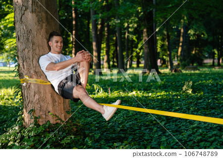 Man experiencing slacklining in the park Man experiencing slacklining in the park 106748789