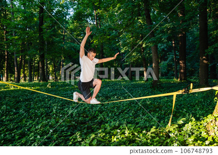Man in sportswear balancing on the rope Man in sportswear balancing on the rope 106748793