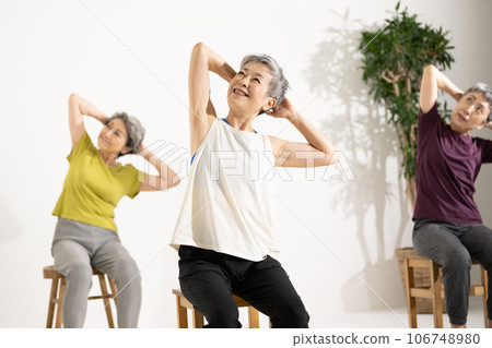 Senior yoga/woman in her 60s doing chair yoga 106748980