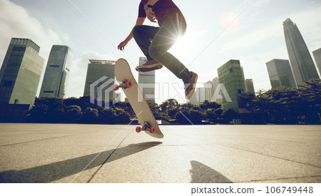 Asian woman skateboarder skateboarding in modern city Asian woman skateboarder skateboarding in modern city 106749448