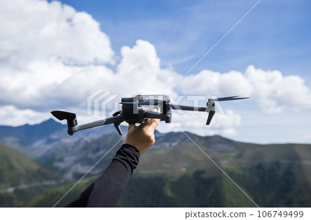 Flying drone in high altitude mountains Flying drone in high altitude mountains 106749499