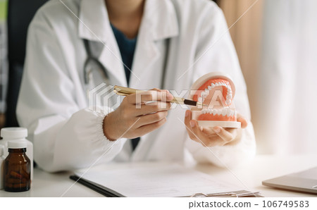 dentists writes reports of working with tooth models and analyzing dental treatments. 106749583