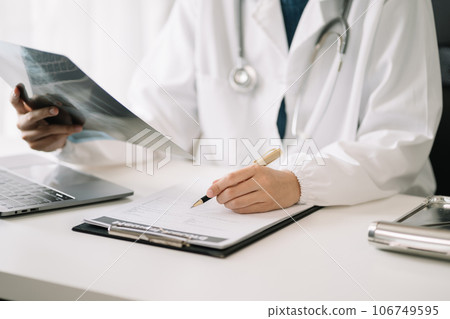 doctor working on digital tablet healthcare doctor technology tablet using x-ray film analyzed the results of medical reports. doctor working on digital tablet healthcare doctor technology tablet using x-ray film analyzed the results of medical reports. 106749595