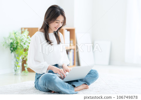 操作一台個人計算機的少婦在客廳 106749878