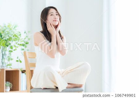 Young woman doing skin care in the living room 106749901