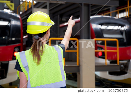 Young caucasian engineer woman or worker pointing and checking electric train for planning. 106750875