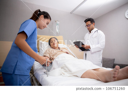 Doctor checkup and diagnostic while nurse measuring blood pressure with patient elderly at hospital. 106751260