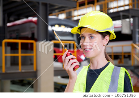 Young caucasian engineer woman using radio for command with worker. Young caucasian engineer woman using radio for command with worker. 106751386