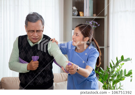 Asian caregiver woman or nurse training senior man stretch arm for exercise while therapy. Asian caregiver woman or nurse training senior man stretch arm for exercise while therapy. 106751392