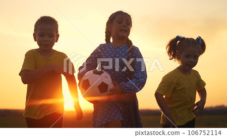 children run in the park silhouette a playing ball. happy family kid dream concept. a group of children playing catch-up holding a ball silhouette in nature. family children run in the park lifestyle children run in the park silhouette a playing ball. happy family kid dream concept. a group of children playing catch-up holding a ball silhouette in nature. family children run in the park lifestyle 106752114