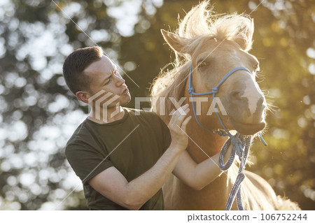Man calming horse during obedience training 106752244