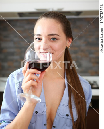 Young beautiful attractive girl drinks wine Young beautiful attractive girl drinks wine 106752718