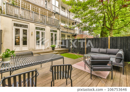 a patio with furniture and trees in the back yard, as seen from the outside looking into the living room a patio with furniture and trees in the back yard, as seen from the outside looking into the living room 106753646