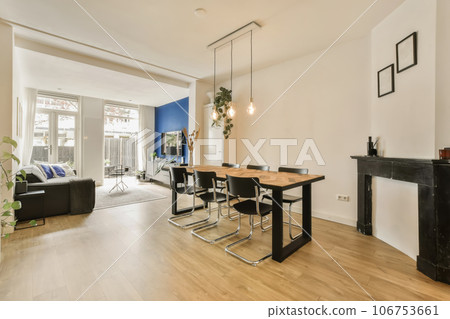 a living room with wood flooring and white walls, an open fire place in the center of the room 106753661