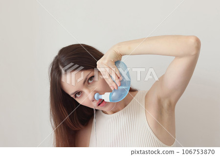 Nasal irrigation. A young woman uses the Neti Pot to treat her runny nose and colds. Nasal lavage, irrigation therapy. Nasal irrigation. A young woman uses the Neti Pot to treat her runny nose and colds. Nasal lavage, irrigation therapy. 106753870
