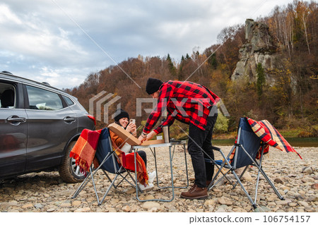 couple having picnic at autumn mountain river 106754157