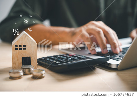 Pressing calculators, hand plans home refinance. House model, buy or rent, calculators on desk. Saving for property purchase, optimal mortgage payment. Tax, credit analysis for financial planning. Pressing calculators, hand plans home refinance. House model, buy or rent, calculators on desk. Saving for property purchase, optimal mortgage payment. Tax, credit analysis for financial planning. 106754637