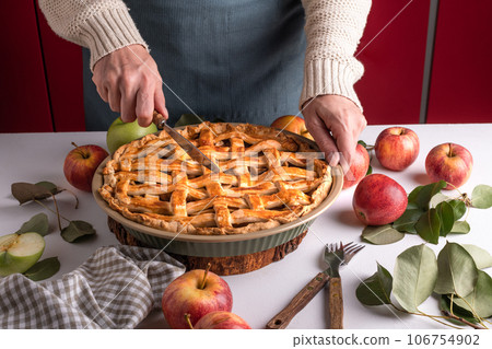 Woman cutting a baked apple with a khife, Thanksgiving traditional dessert ready to eat Woman cutting a baked apple with a khife, Thanksgiving traditional dessert ready to eat 106754902